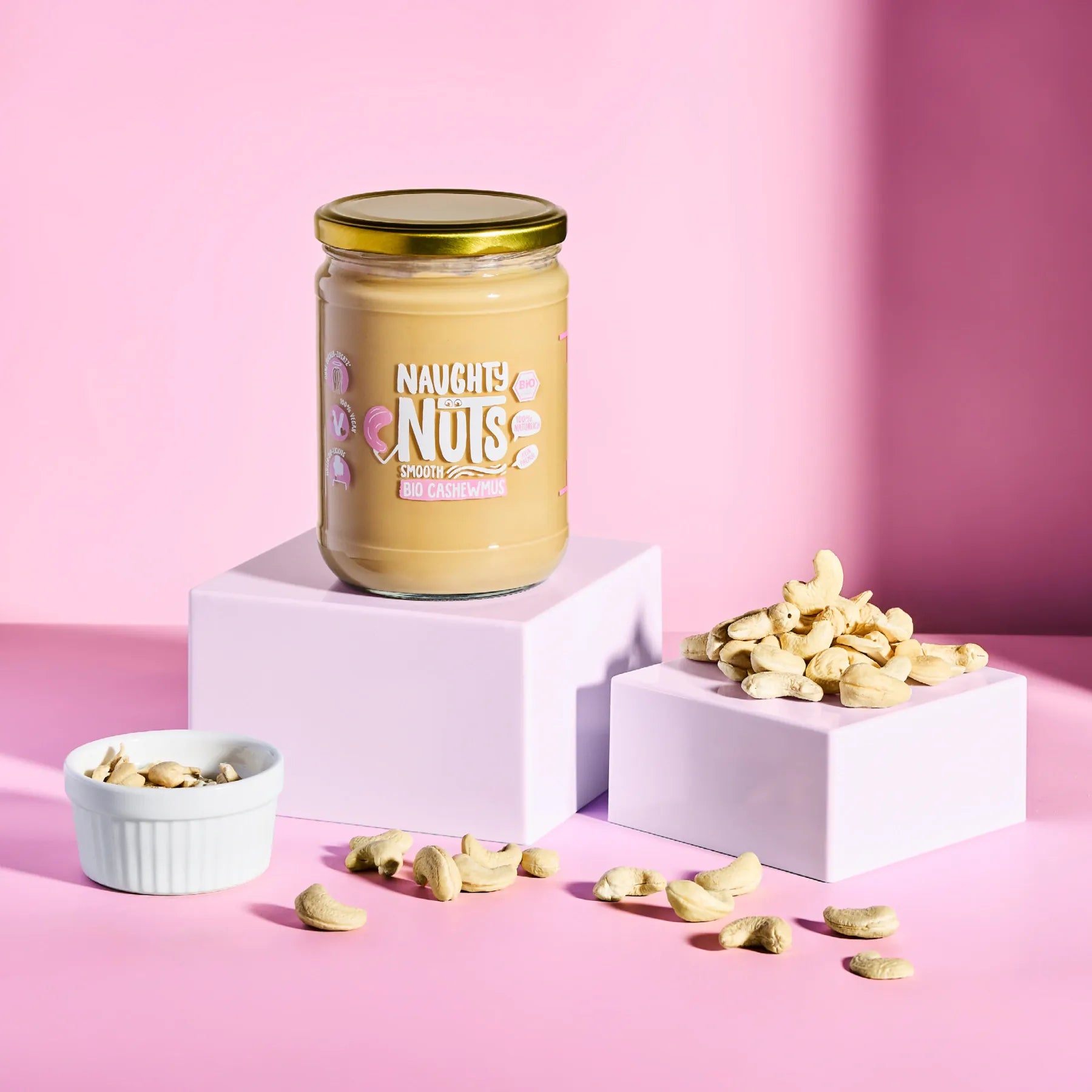 Bio Cashewmus Smooth im Glas auf einem Podest mit Cashewkernen